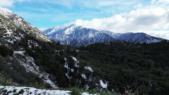 The California San Gorgonio San Bernardino Mountain Range near theSanta Ana River in the Watershed looking at the Mountains and trees covered in Snow after a Winter Storm from a UAV Drone Aerial Shot 