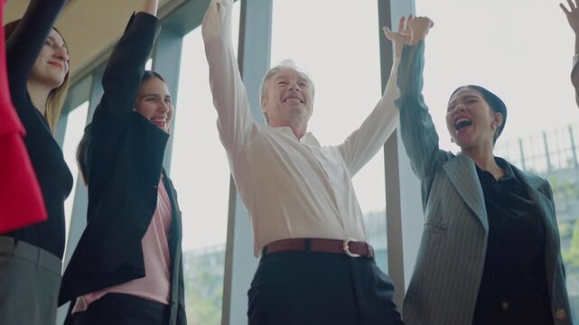 Rising Upward: A dynamic group of business people, energized by success and unity, celebrates their accomplishments together, with raised arms and uplifted spirits.
