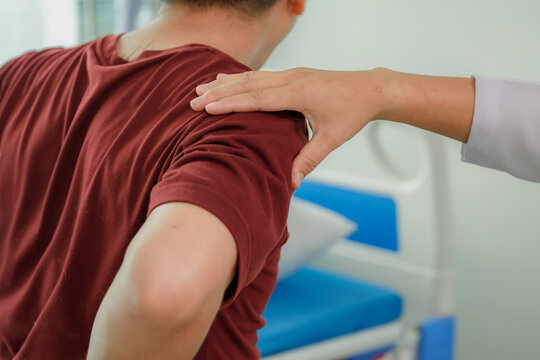 Specialist using trigger point massage on a patient's shoulders and upper back.
