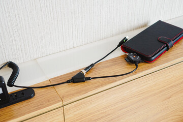 外出先でスマートフォンと旧型携帯電話を充電するマルチチャージャー　ケーブル交換型マルチ充電器 © honey