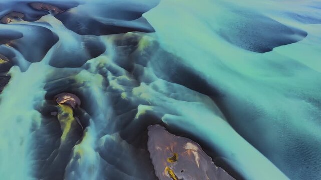 Aerial view of braided glacial rivers with turquoise water flowing through volcanic sand in Landmannalaugar, Rangarthing ytra, Iceland.