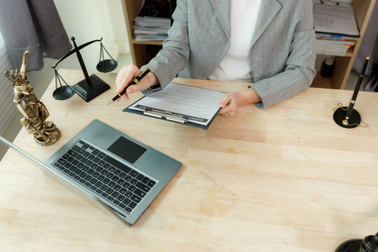 Attorney's hand carefully signing a finalized and vetted employment agreement, confirming legal compliance and accuracy.
