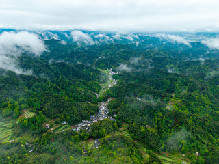 Fototapeta premium An aerial view shows the traditional village of Huizhou Ancient City located in the rural mountains of She County in Anhui province of China during a misty and cloudy morning