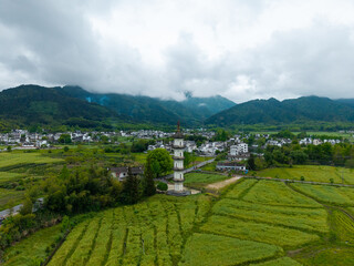 Obraz premium An aerial view captures the traditional architecture of the ancient Hongcun Village located in Yixian County of Anhui Province in China with lush green fields and mountains in the background