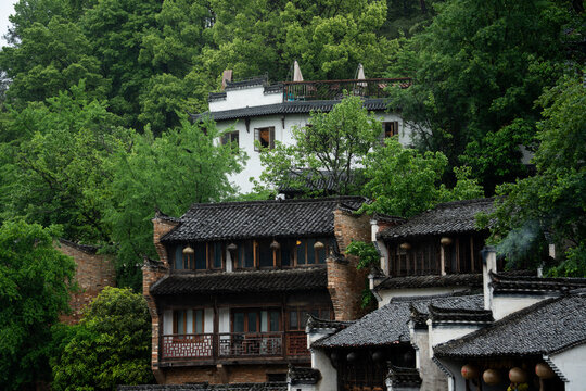 A view of traditional architecture featuring ancient villages nestled among lush green trees in the scenic mountains of Northeast Jiangxi in China 