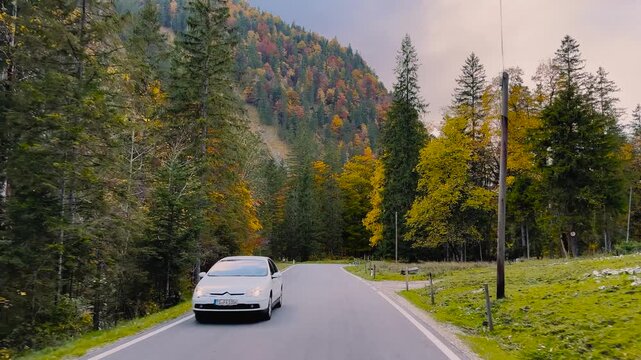 Driving shot through the windshield on a mountain road in the Ammergebirge, Austria, autumn sun.