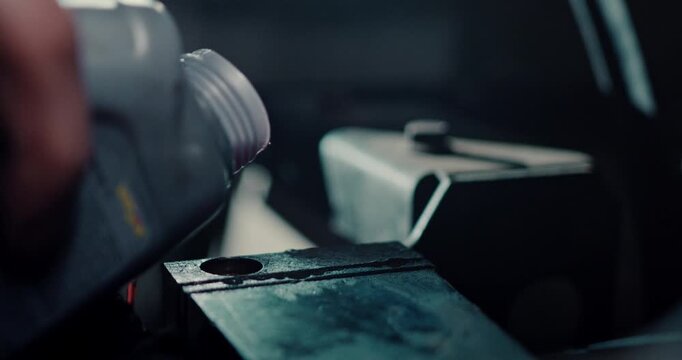 A person is filling up with oil and misses the whole a bit.