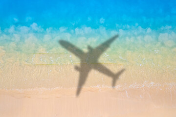 Aerial view of shadow passenger plane silhouette and sandy beach blue sea with waves at sea beach summer vacation sea travel concept  © Media 