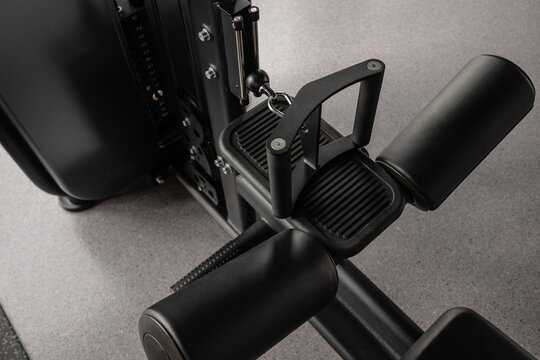 Close-up of leg extension machine seat and pads in modern gym equipment detail