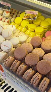 Brightly colored macarons organized in glass showcase with labels