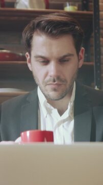 Individual enjoys warm beverage, An individual takes break from work to enjoy warm cup of coffee in kitchen