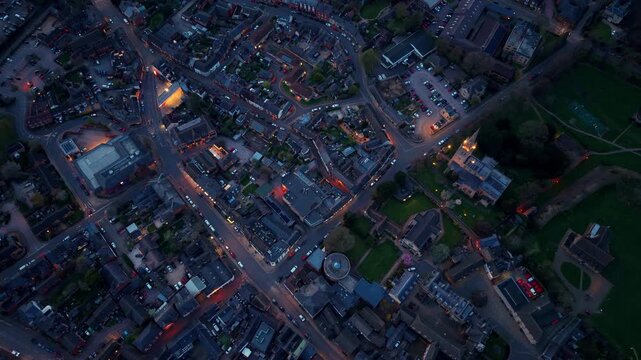 Aerial view of the historic town of Oakham at dusk with street lights illuminating the urban layout and rooftops in Oakham, England, United Kingdom.