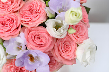 Obraz premium Elegant floral arrangement showcasing vibrant pink roses, delicate white eustoma, and fragrant purple freesias in a lush bouquet, symbolizing beauty and joy