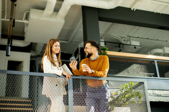 Two colleagues sharing ideas and laughter in a modern office setting
