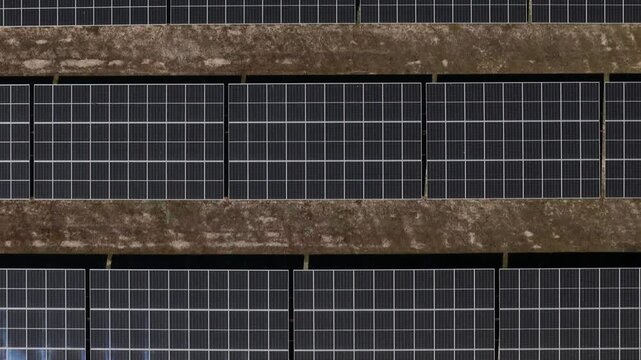Aerial view of rows of solar panels in a photovoltaic power plant on dark soil in Palmela, Setubal, Portugal.