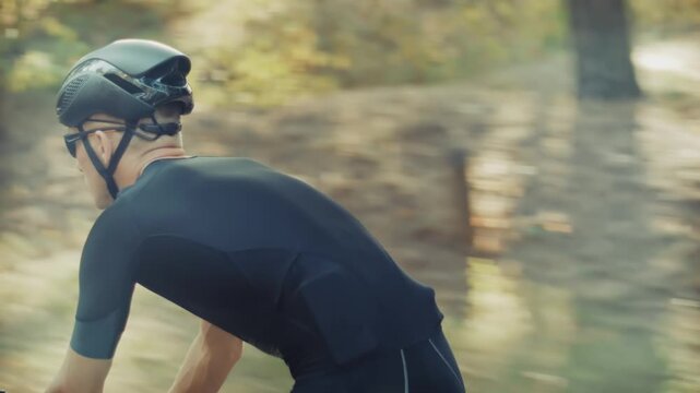 Cyclist Riding Road Bike Through Forest During Intense Training Session. High Performance Cycling Workout In Nature