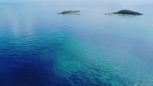 Abrolhos Archipelago near Caravelas Bahia Brazil with low volcanic islands separated by clear South Atlantic water over coral reef system within marine national park, forward flyover shot