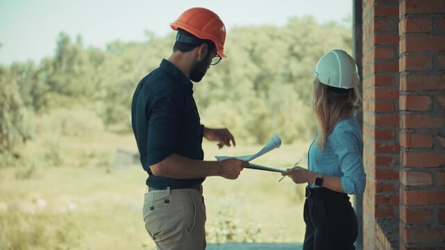 Discussing Blueprints at Building Construction Site. Planning Infrastructure Development. Reviewing Project Documents on Location