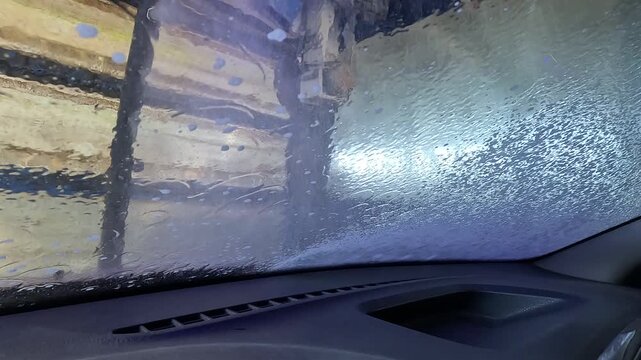 Video with sound. A Thrilling Journey Through a Car Wash: Experiencing the Transformation as the Vehicle Gets Cleansed and Pampered in a Sudsy Environment