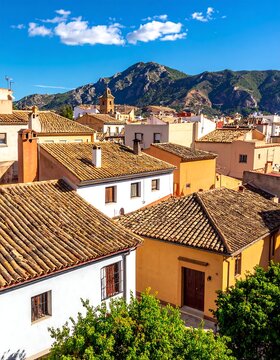 Sunny rooftops of a town, mountains visible in the distance