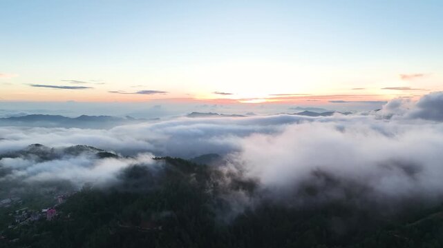 Breathtaking aerial drone footage flying high above a dense sea of clouds during a golden sunrise in the Himalayas near Shimla, India.