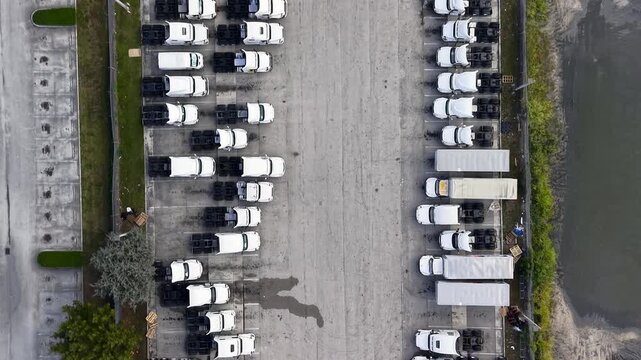 Aerial top down view of trucks moving in a parking lot