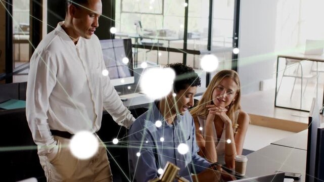 Seated man typing and causing tech overlay on laptop, team watching, nodes flaring, confirming data