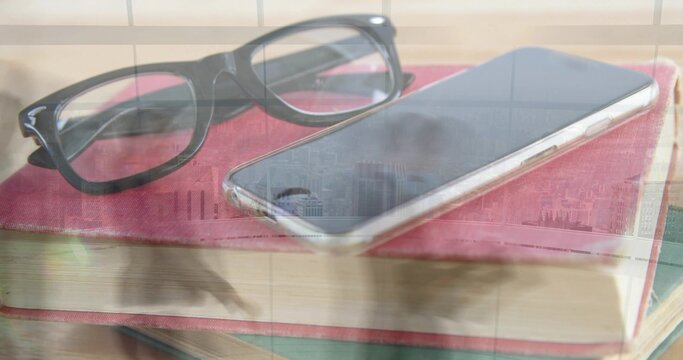 Resting black rectangular glasses and smartphone sitting on red book in study, window reflection