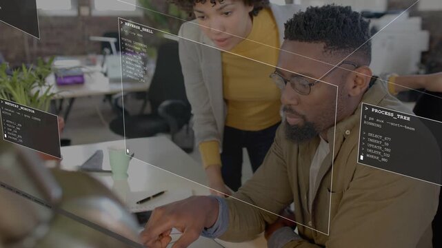 Standing woman pointing causing code overlays on laptop while seated man tapping debugging software