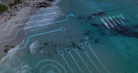 Fototapeta premium Showing aerial turquoise ocean with circuit overlay at beach, umbrellas and beachgoers in swimsuits