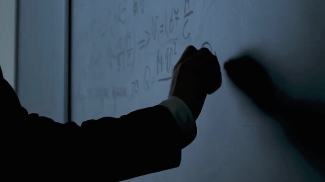 Scientist Writing Physics Formulas on Chalkboard Close Up