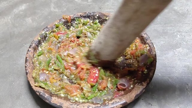Process of Grinding Fresh Green Chili Sambal in Traditional Stone Mortar
