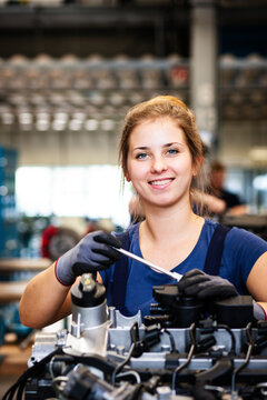 Eine junge Mechanikerin arbeitet an einem Motorblock in einer Werkstatt. KI generiert