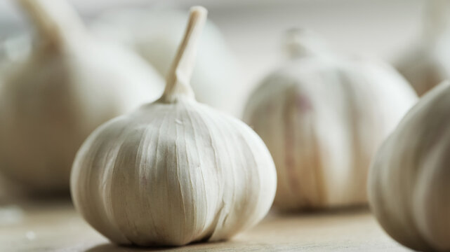 Close up garlic on rustic table with sunlight from window creating soft glow and natural kitchen setting