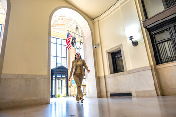 Professional woman walking through us government building archway