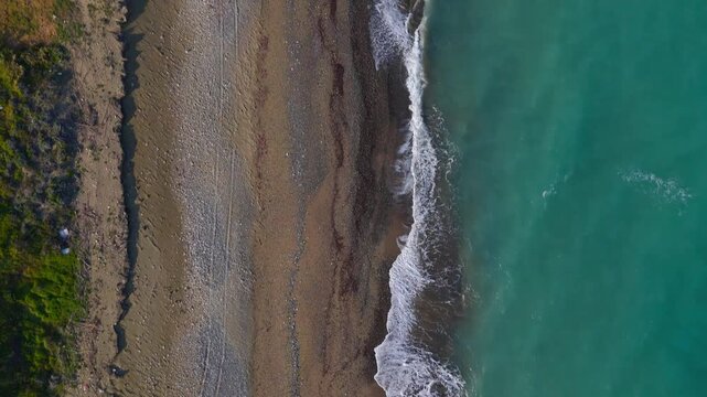 Aerial Top Down View of Mavralis Shingle Beach and Turquoise Mediterranean Sea in Cyprus