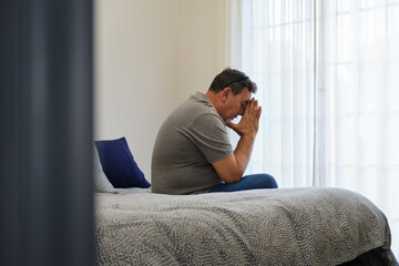 Fototapeta premium general view of Mature man feeling stressed and worried sitting on bed