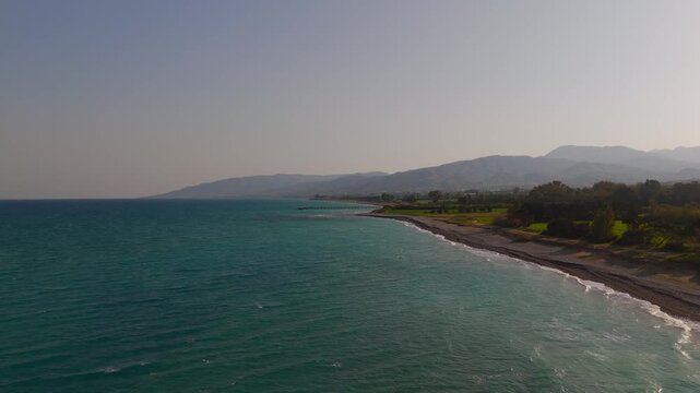 Cinematic Drone Approach to Quiet Mavralis Beach and Wooden Pier in Cyprus