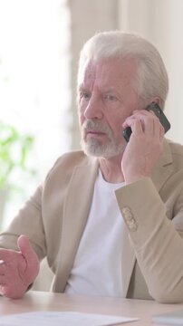 Old Man Talking on Phone in Office, Vertical Video