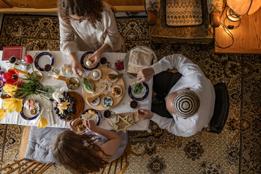 Multigenerational family celebrating Passover seder indoors