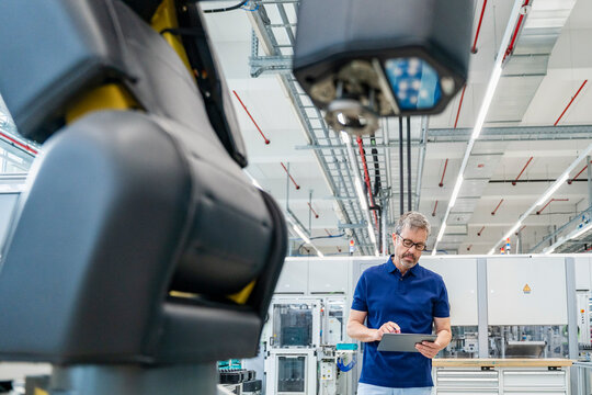 Engineer using tablet in modern industrial factory with automation