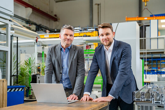 Managers with a laptop in an indoor production hall