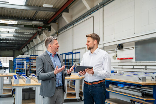 Manager and engineer discussing in a production hall