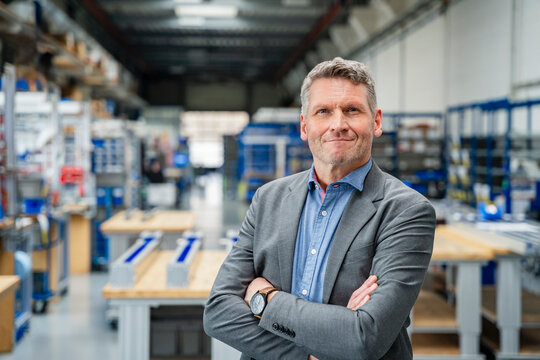 Confident businessman smiling in a factory production hall