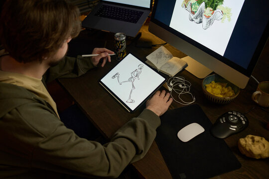 Illustrator creating digital art on a graphics tablet indoors