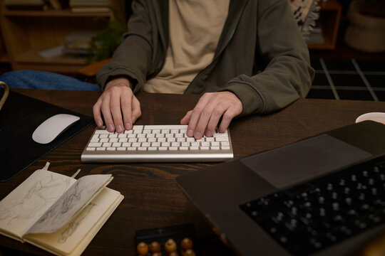 Digital artist typing on keyboard at a home office desk