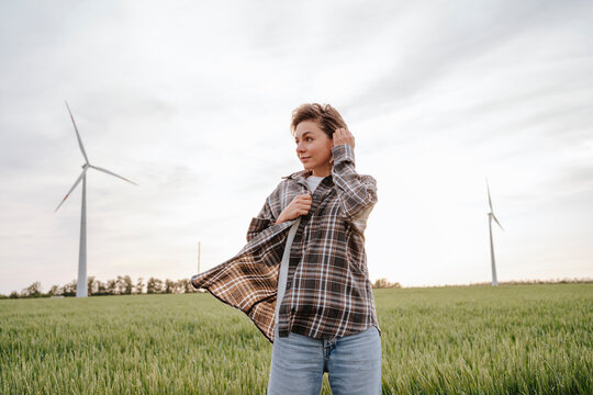 Beautiful woman enjoying at field of wind turbines