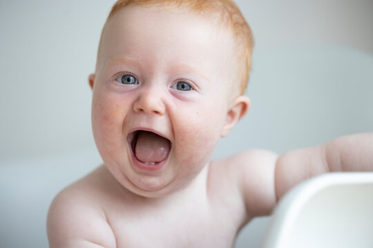 Laughing portrait with red hair and open mouth looking at camera