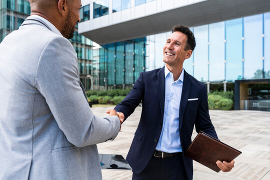 Coworkers shaking hands outdoors in the financial district