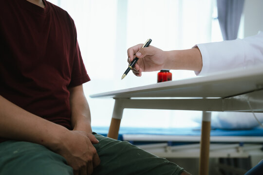 Doctor consulting a male patient about prostate health and urinary tract inflammation in a clinic, discussing symptoms and treatment during a medical checkup.